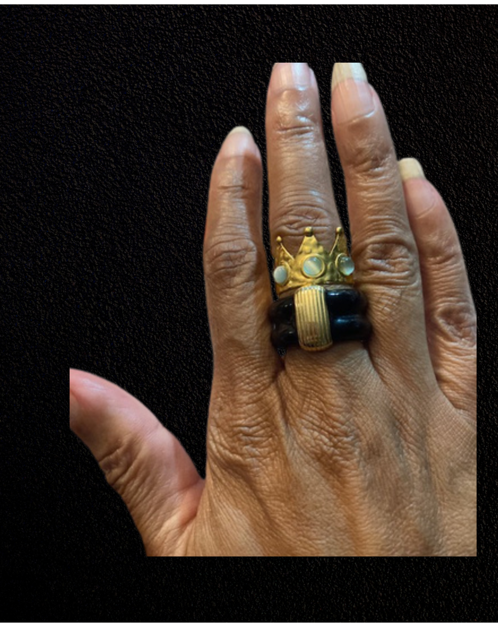 Black French enamel ring with a gold-tone vertical bar stacked with a green aventurine crown ring on a hand.